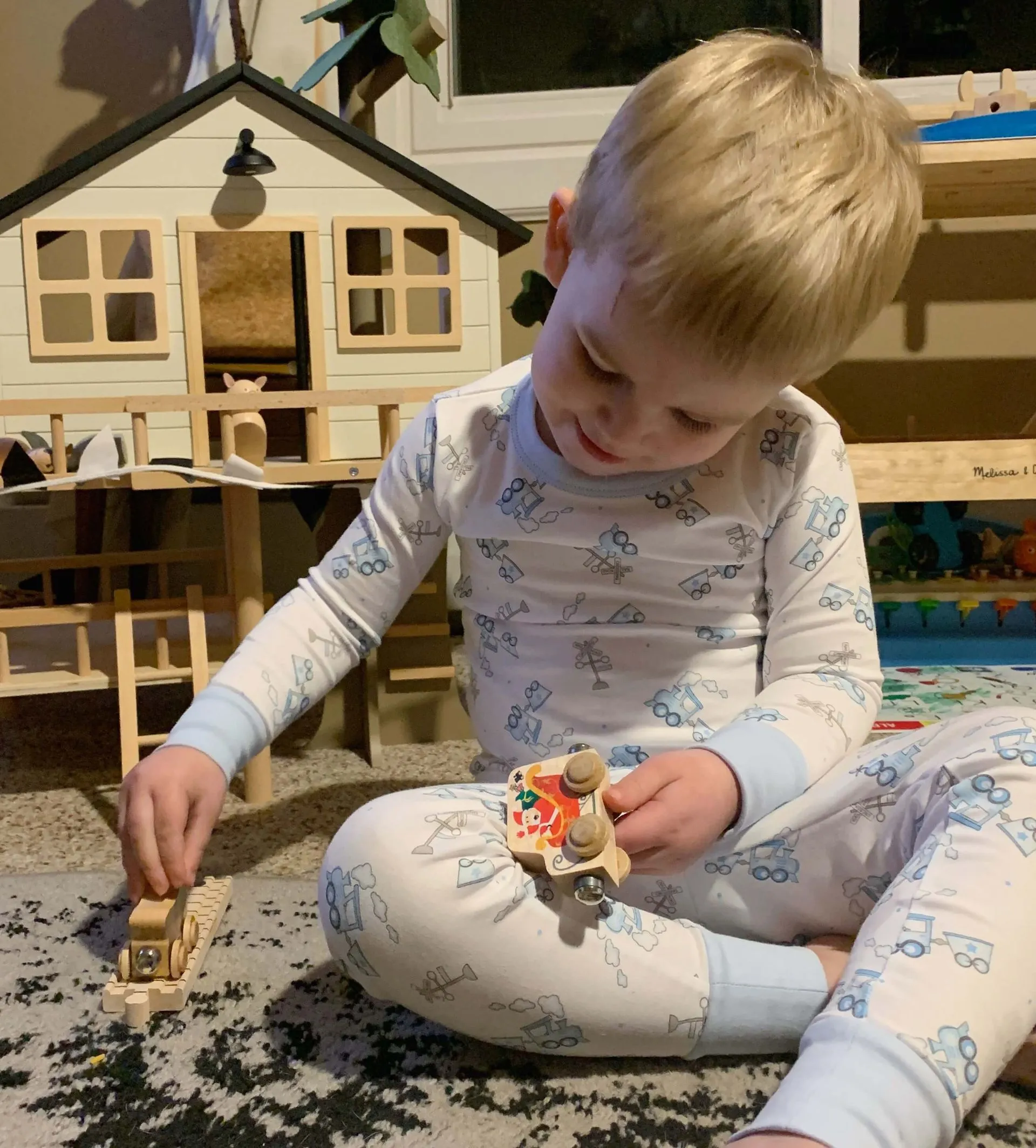 A little boy is sitting on the floor playing with toys