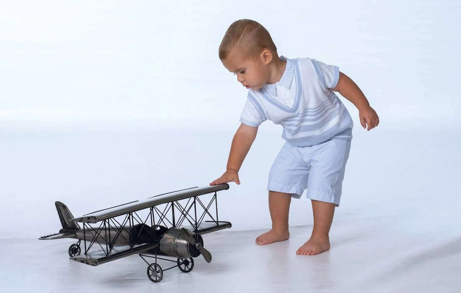 A little boy is playing with a toy airplane
