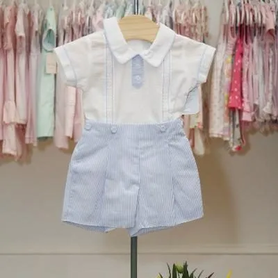 A baby boy is wearing a white shirt and blue striped shorts.
