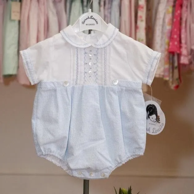 A baby 's blue and white outfit is hanging on a hanger