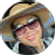 A woman wearing a hat and sunglasses is smiling in a circle.
